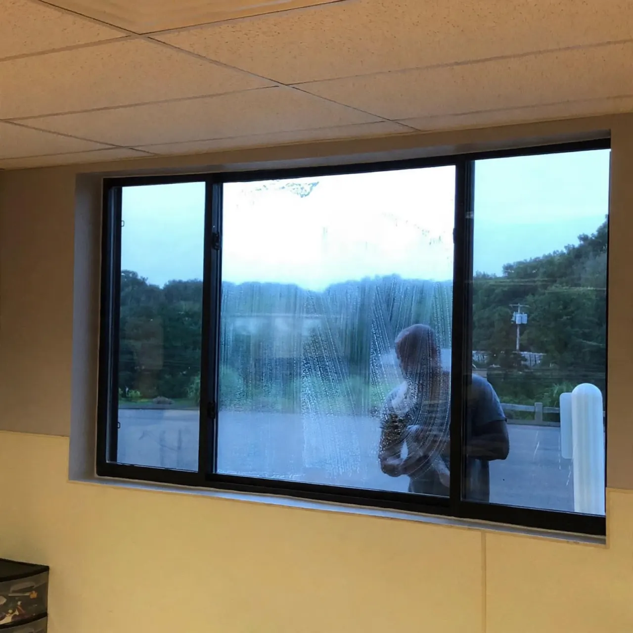 Burgos Cleaning team member cleaning interior windows at a commercial property