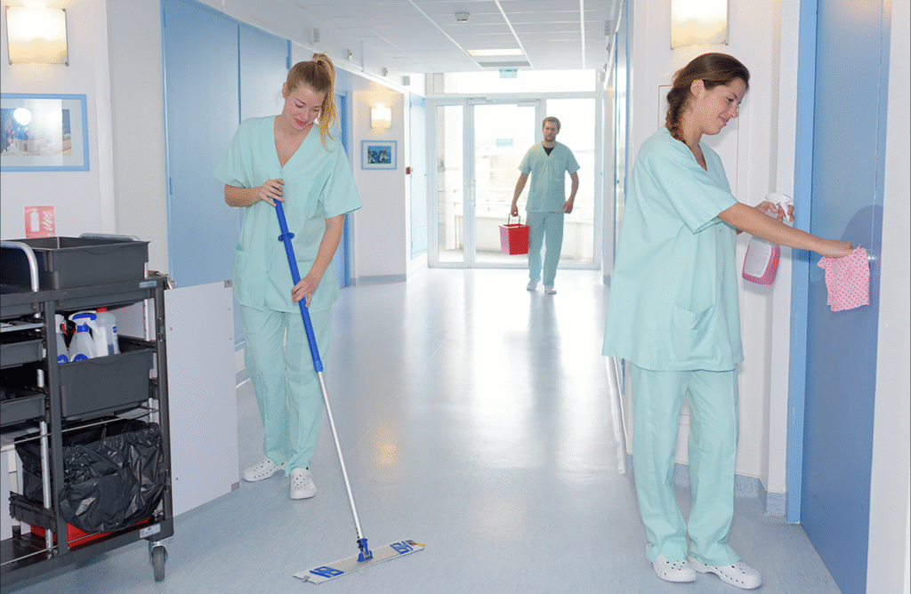 a group of people in scrubs cleaning the floor