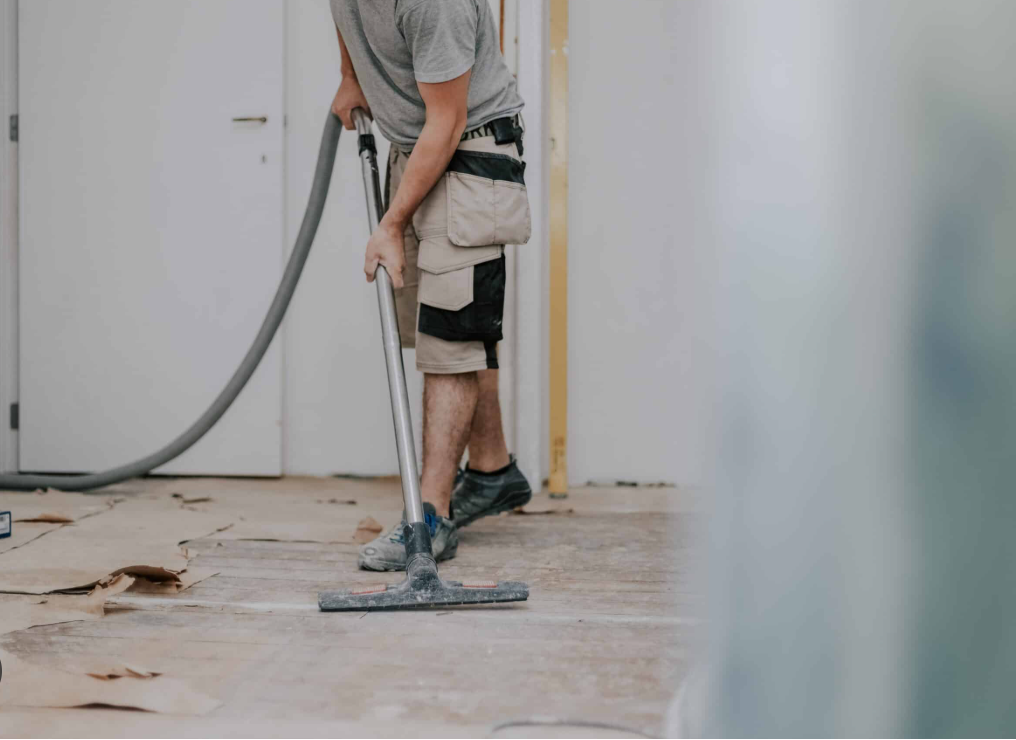 a man vacuuming the floor